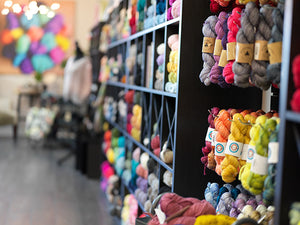 A wall of yarn at Skein Yarn Shop in East Greenwich, RI with Madelintosh and OntheRound
