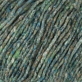 Closeup of yarn that shows as a rich, deep green shade with flecks of blue and black.