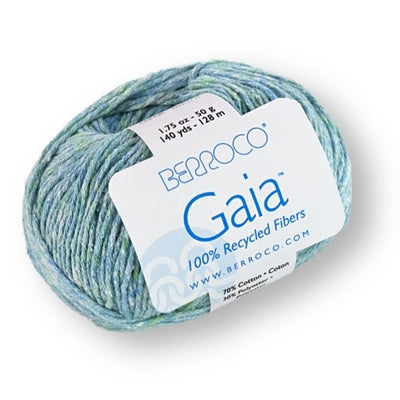 Close up of a Berroco Gaia yarn ball in an ocean blue color.  Label reads "100% recycled fibers" emphasizing the brand's commitment to be eco-friendly.