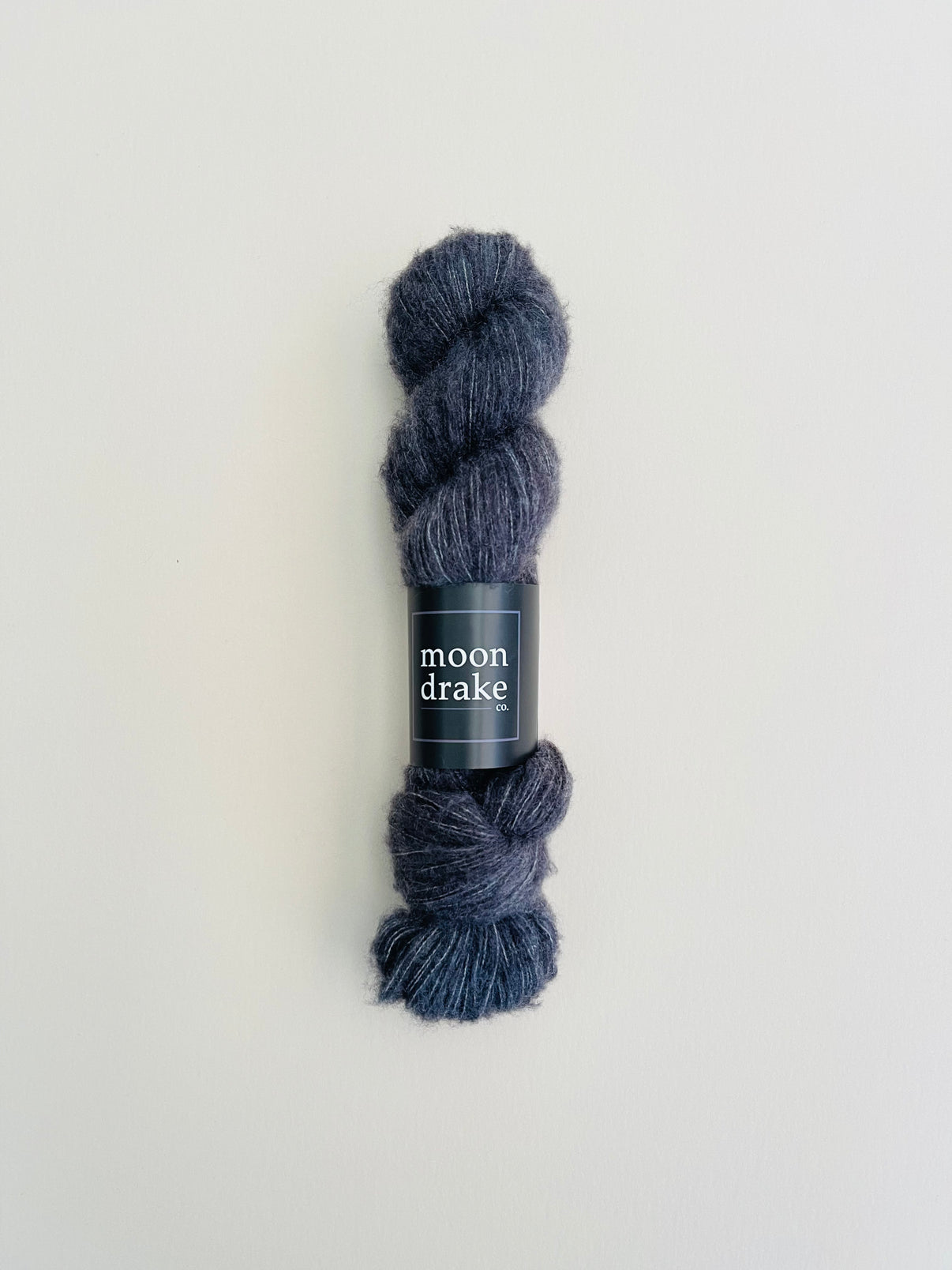 A deep cool grey skein of brushed cashmere fingering weight yarn.