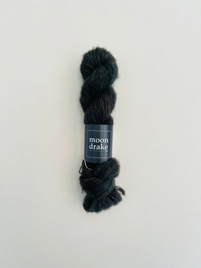 An extremely fuzzy skein of black brushed cashmere and merino yarn.