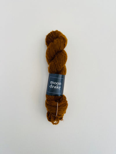 A warm brown skein of yarn with visibly fuzzy texture.