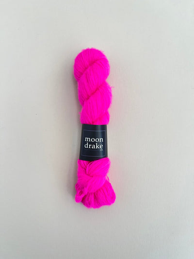 A vivid hot pink neon skein of brushed cashmere and merino yarn.