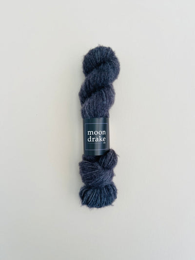 A stormy blue skein of textured cashmere yarn that has a very soft halo.