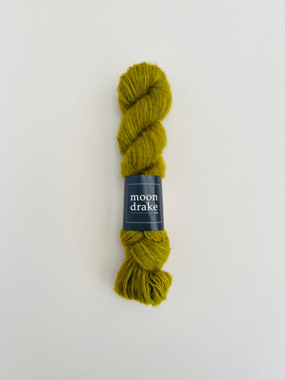 A moss green skein of floofy textured yarn.