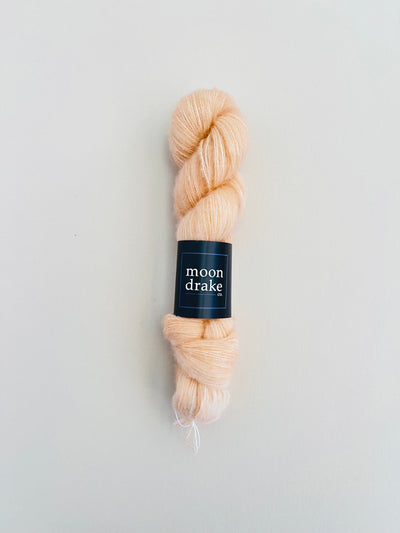 A warm almond skein of yarn with a fuzzy texture.